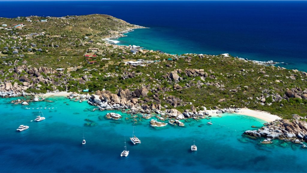 Aerial view of The Baths and Devils Bay, Virgin Gorda, featuring giant granite boulders, crystal-clear turquoise waters, and lush tropical scenery in the British Virgin Islands.