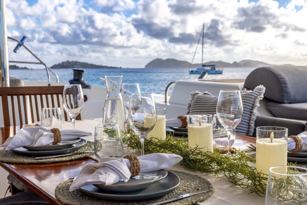 Chef-prepared fine dining table set on the deck of a crewed yacht charter in the BVI
