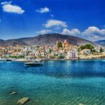 Luxury yachts docked in a Mediterranean harbor in Greece during the yacht charter season.