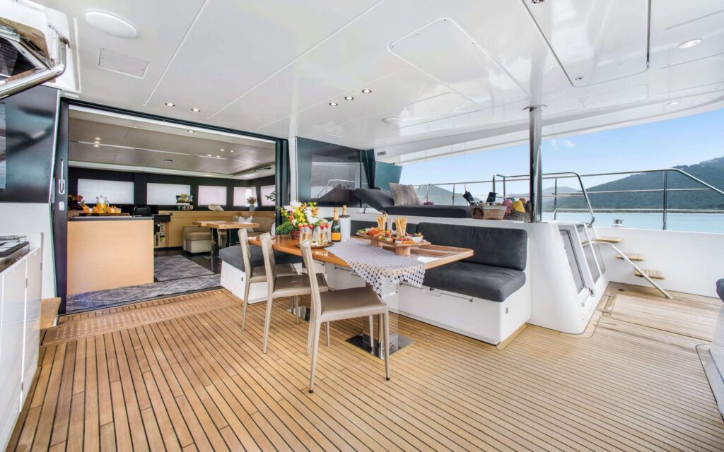 Aft deck dining area set for lunch on an all-inclusive charter yacht